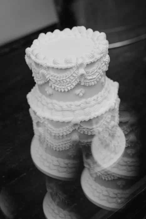 Elegant tiered wedding cake with intricate piped detailing displayed during the celebration at Infante Sagres.