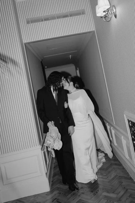 Bride and groom walking through a striped hallway together at Infante Sagres hotel, sharing a quiet moment after the ceremony.