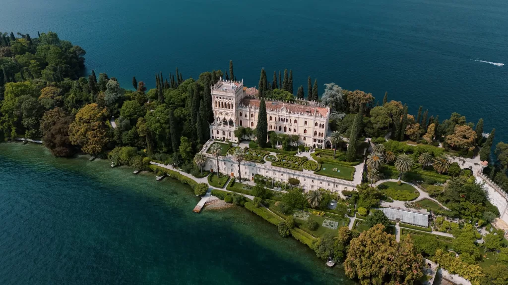 Aerial view of Isola del Garda showcasing villa, formal gardens, and surrounding lake
