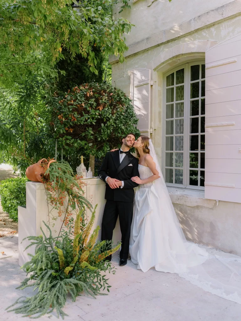 Bride and groom sharing a joyful moment beside a garden bar setup at Mas de Chabran.