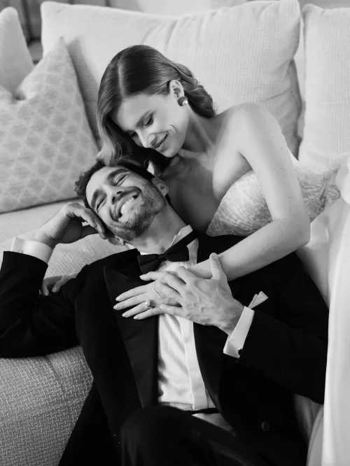 Bride embracing groom as they relax together on a sofa inside Mas de Chabran.