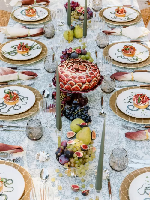 Long reception table decorated with figs, grapes, candles, and elegant place settings at Mas de Chabran.