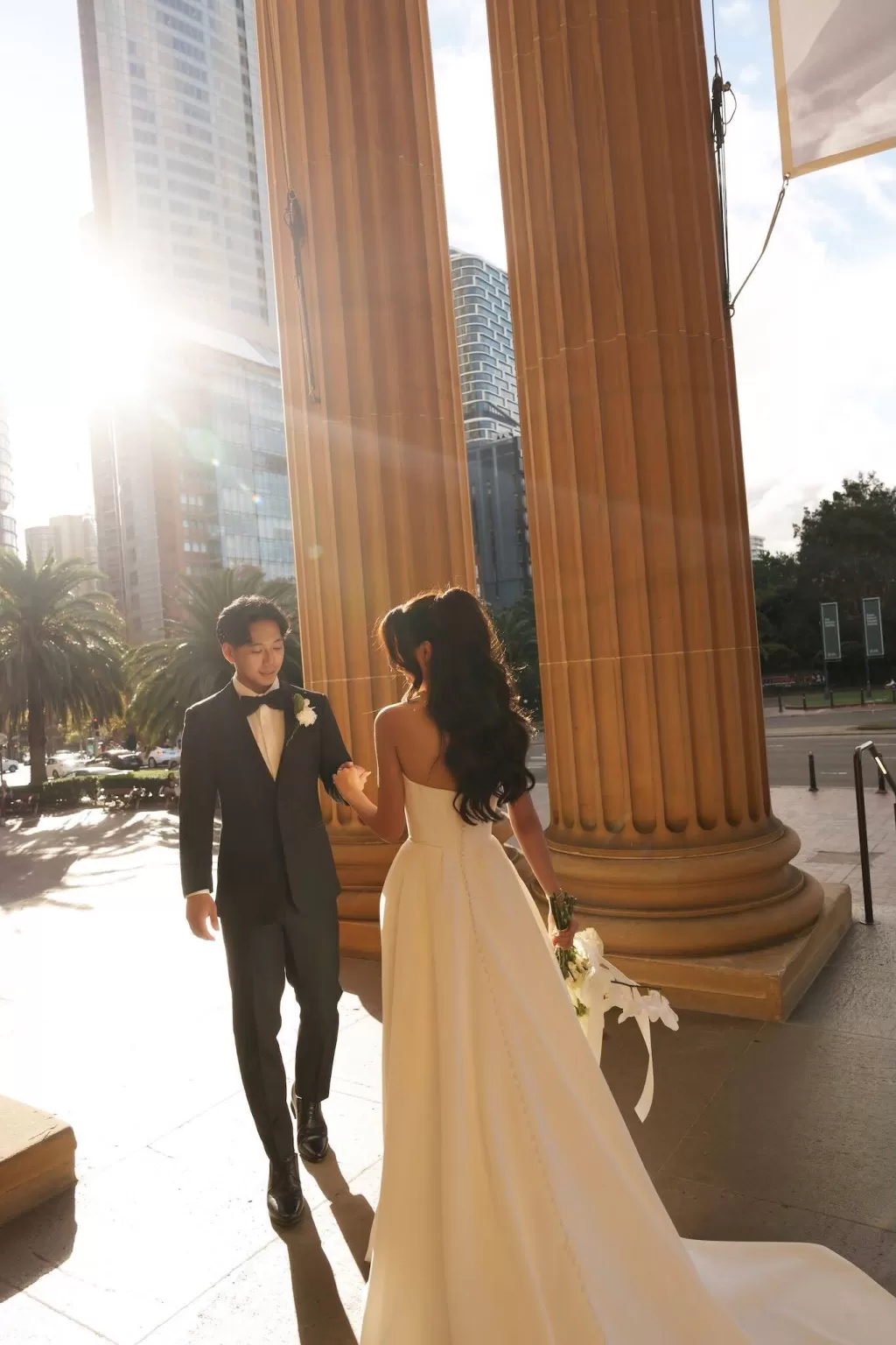 Groom taking the bride’s hand on the sunlit porch of Next Chapter Events.