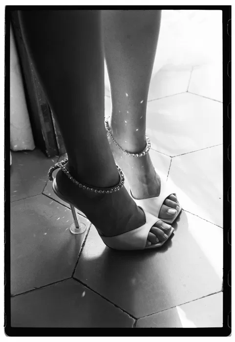 Close-up of bridal heels and ankle jewellery catching light during preparations