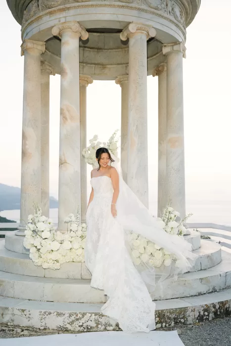 Bride standing at the marble temple at Son Marroig with flowing veil and soft sea backdrop