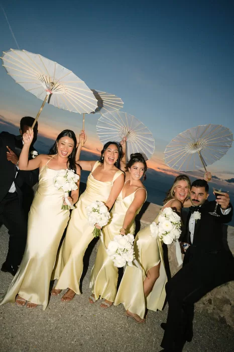 Bridesmaids holding white parasols at sunset at Son Marroig with sea views