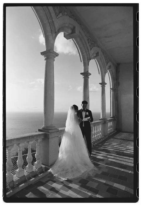 Couple exchanging vows under stone arches overlooking the sea at Son Marroig