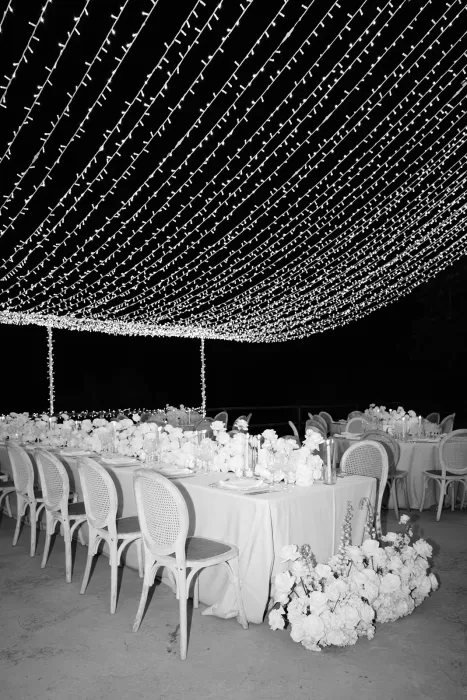 Reception tables under a canopy of fairy lights at Son Marroig in a black and white night scene
