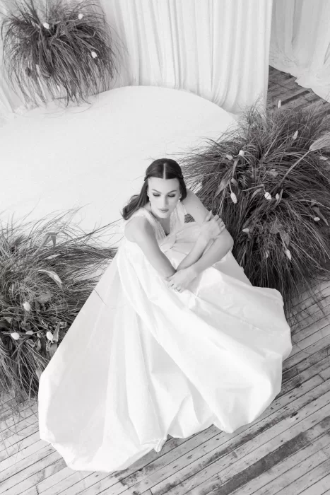 Overhead black and white portrait of bride seated in voluminous gown surrounded by sculptural greenery at Studio Sunset Chicago