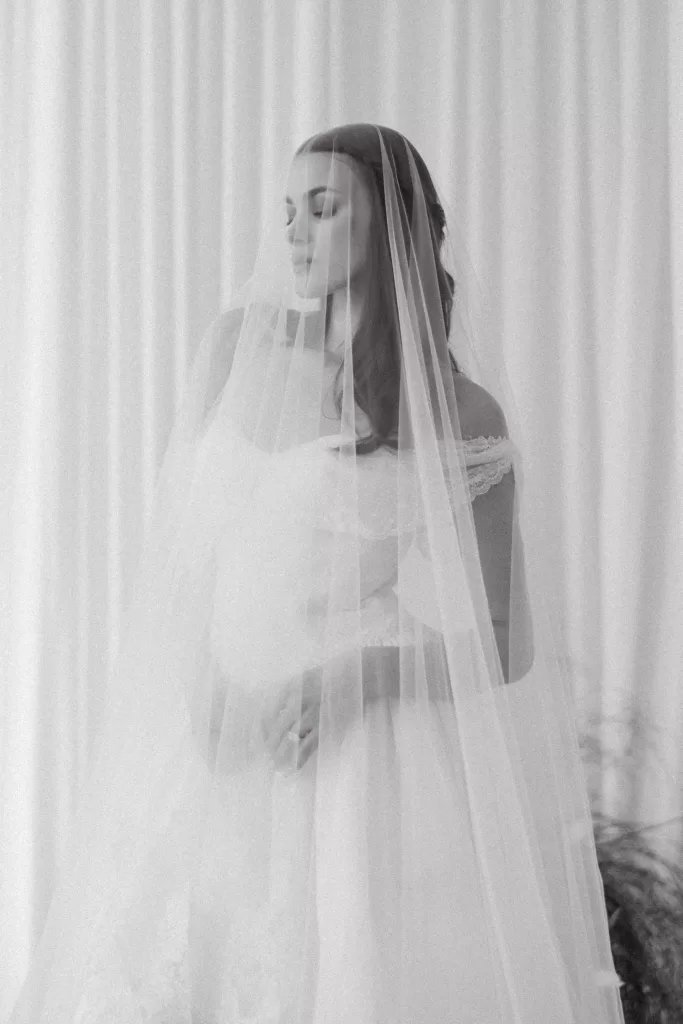 Bride softly framed through veil with diffused light and minimal backdrop at Studio Sunset Chicago