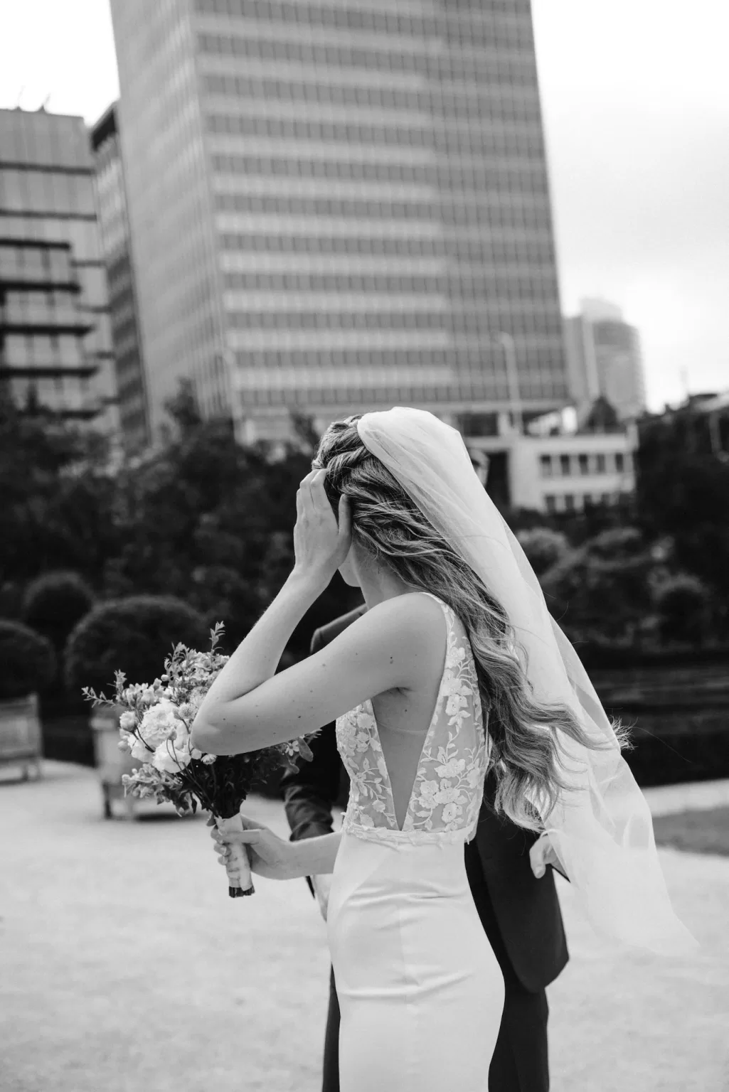 Black and white portrait of bride with veil overlooking city by Anne De Geyter Fotografie