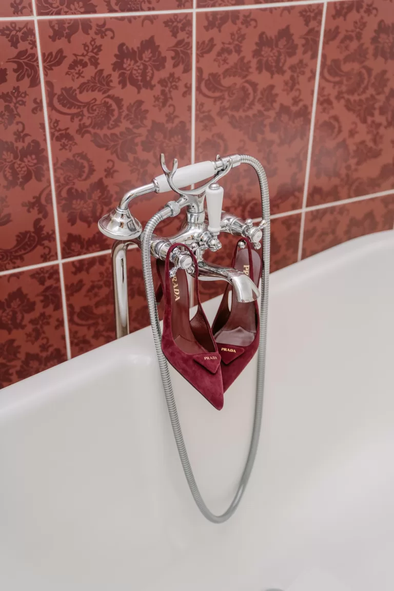 Wedding heels styled on vintage bathtub with patterned tiles by Anne De Geyter Fotografie