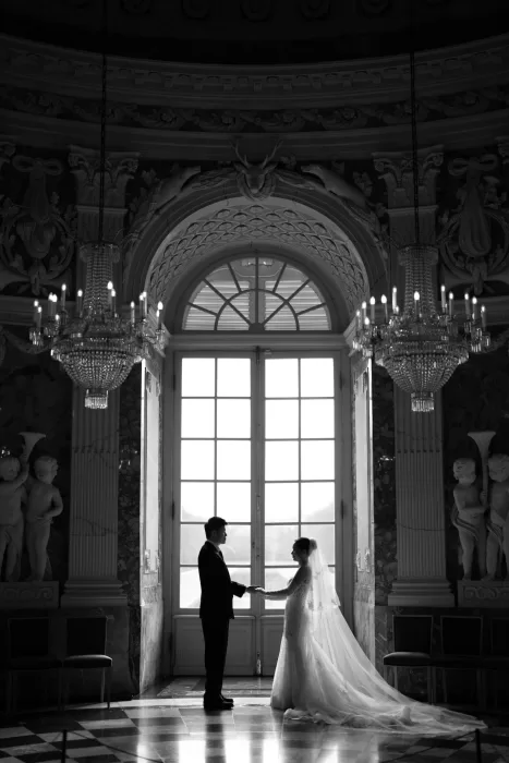 Couple posing on stone steps outside a historic palace building with classical details