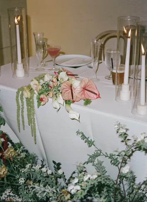 Sweetheart table styled with candles, cocktails and sculptural florals