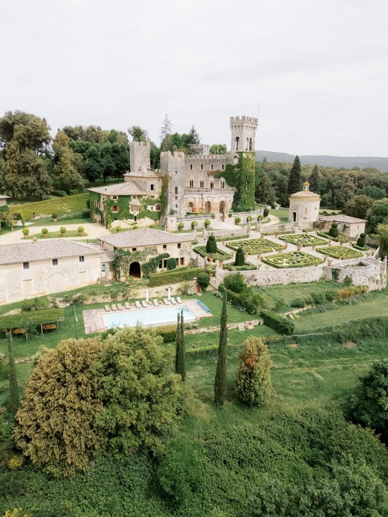 Aerial view of Castello di Celsa surrounded by Tuscan countryside and formal Renaissance gardens.