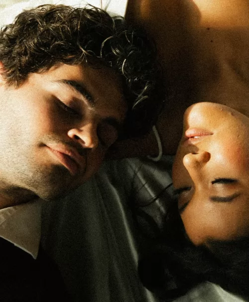 Close-up sunlit portrait of the couple resting together in an intimate, quiet moment.