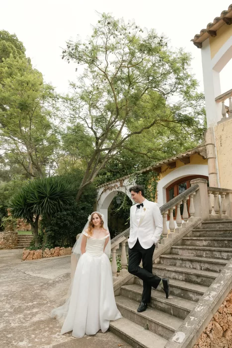 Bride and groom on stone staircase outside villa at Finca Morneta