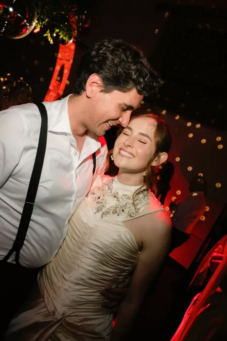 Bride and groom dancing under red lighting during party at Finca Morneta