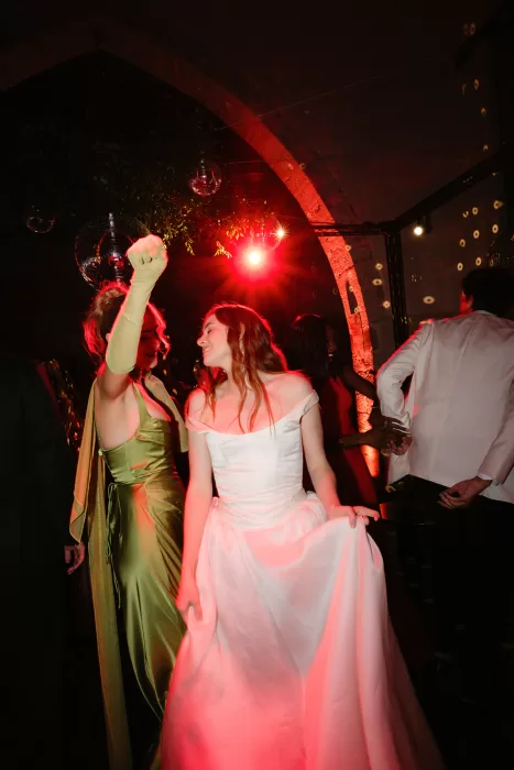 Guests dancing under red lights and disco balls at Finca Morneta party