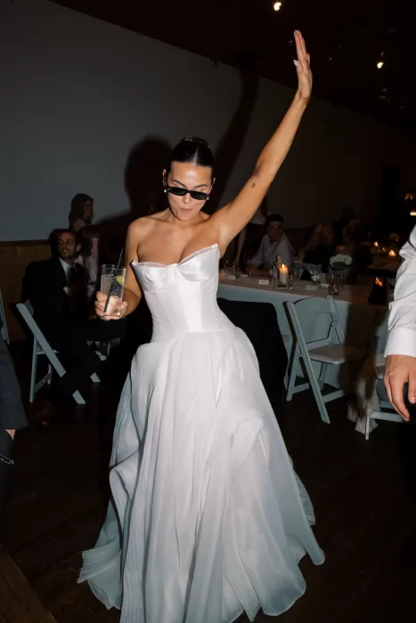 Bride dancing with drink during lively reception at Fraser River Lodge