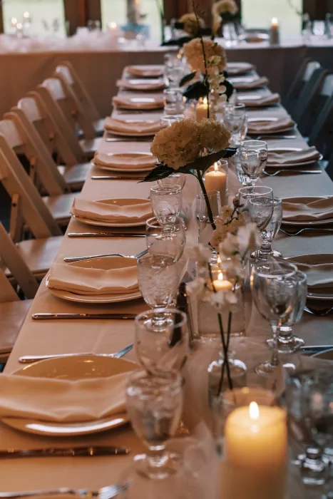 Candlelit reception table with floral arrangements and place settings at Fraser River Lodge