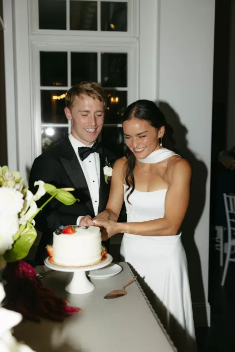 Bride and groom cutting their wedding cake during the reception at The Manor House.