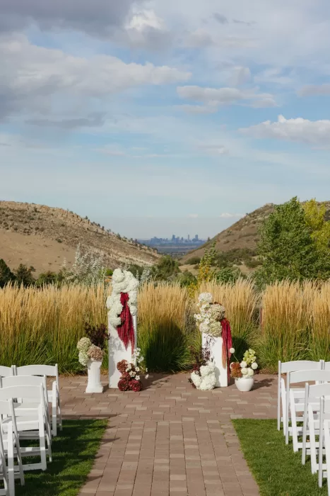 Outdoor ceremony aisle at The Manor House framed by floral arrangements and mountain views.