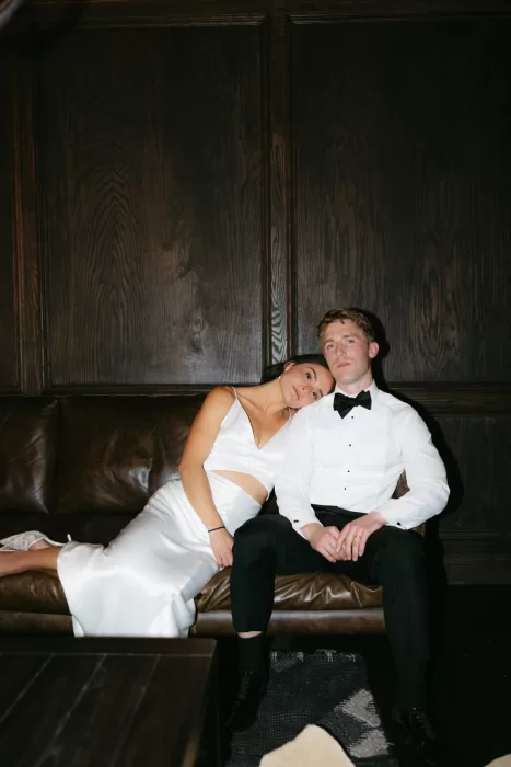 Stylish evening portrait of the couple in a dark wood lounge at The Manor House.