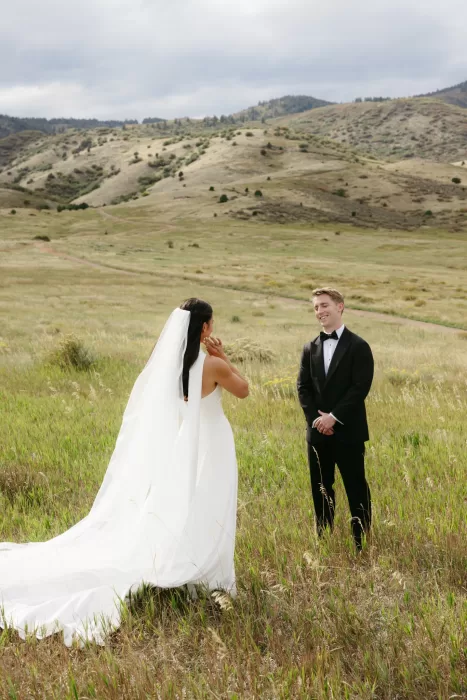 Bride and groom meeting in an open meadow with mountain views near The Manor House