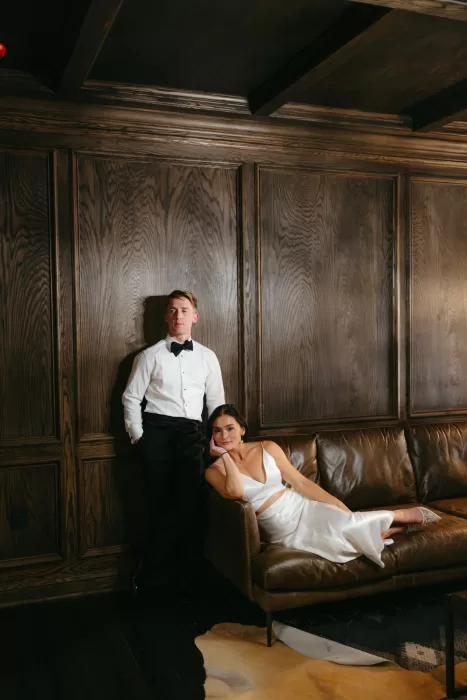 Editorial portrait of the couple in a dark wood lounge inside The Manor House.