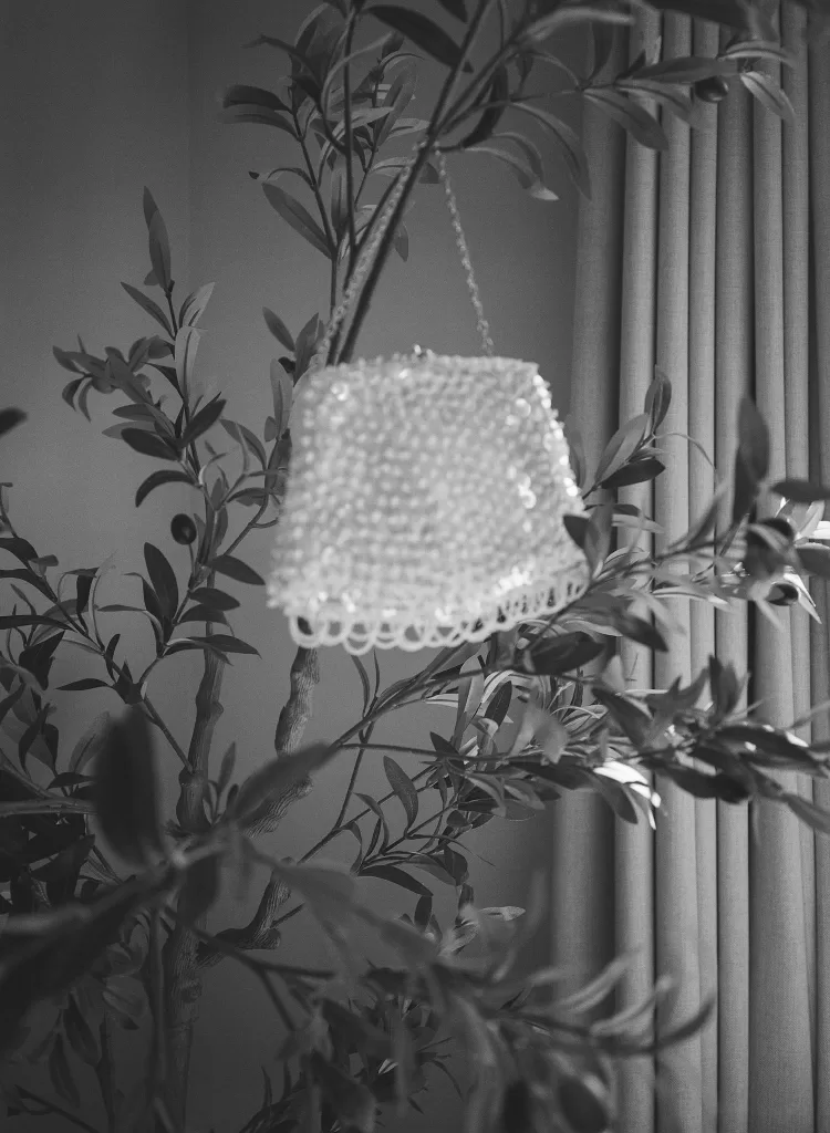 Pearl handbag hanging from a branch in a softly lit interior at Monserate Winery