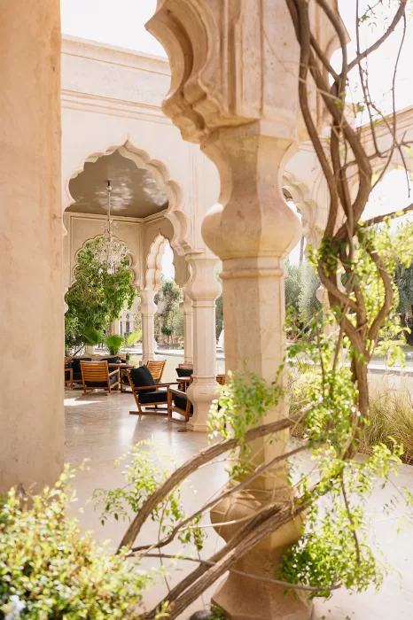 Sunlit lounge seating beneath ornate arches surrounded by greenery at Palais Namaskar