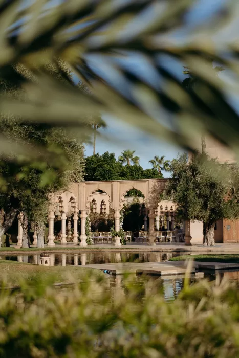 Garden arches reflected in still water surrounded by greenery at Palais Namaskar