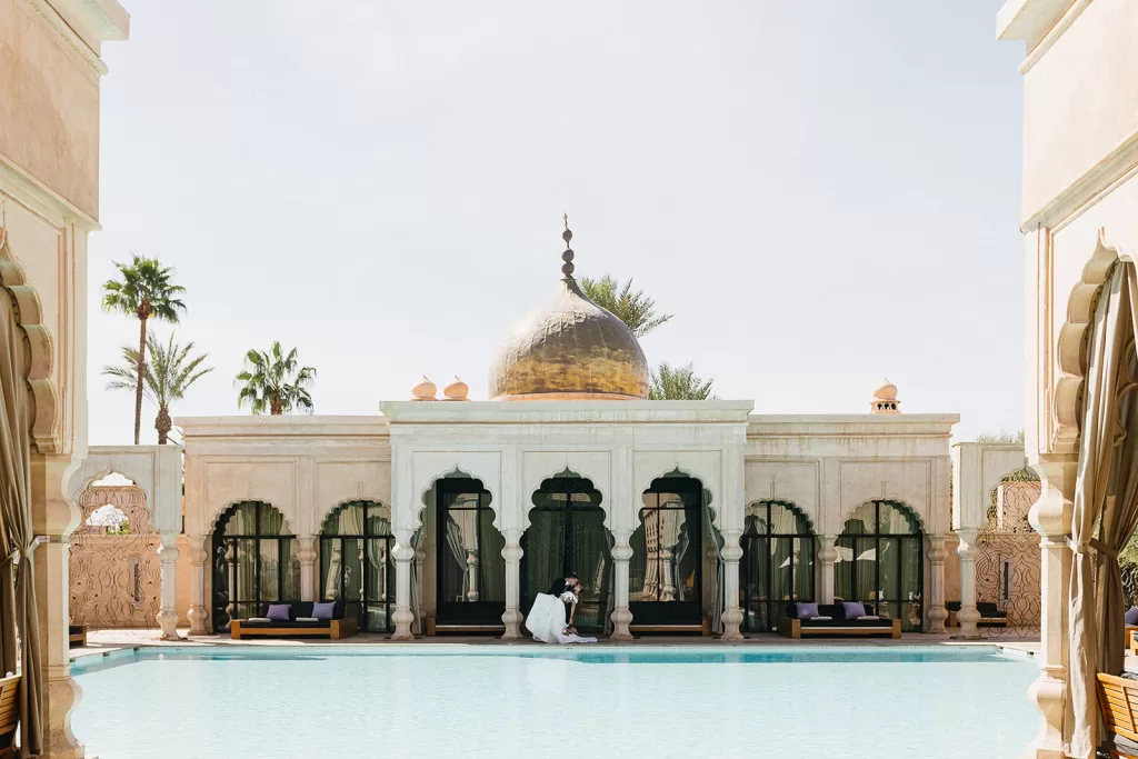 Couple sharing a quiet moment beside reflective pool and domed pavilion at Palais Namaskar