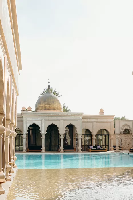 Serene pool with domed pavilion and arched architecture in soft afternoon light at Palais Namaskar