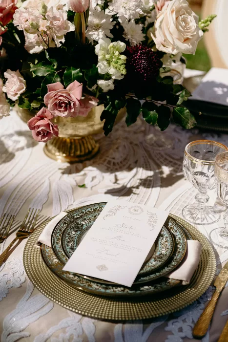 Elegant place setting with floral centerpiece and layered plates at Palais Namaskar reception