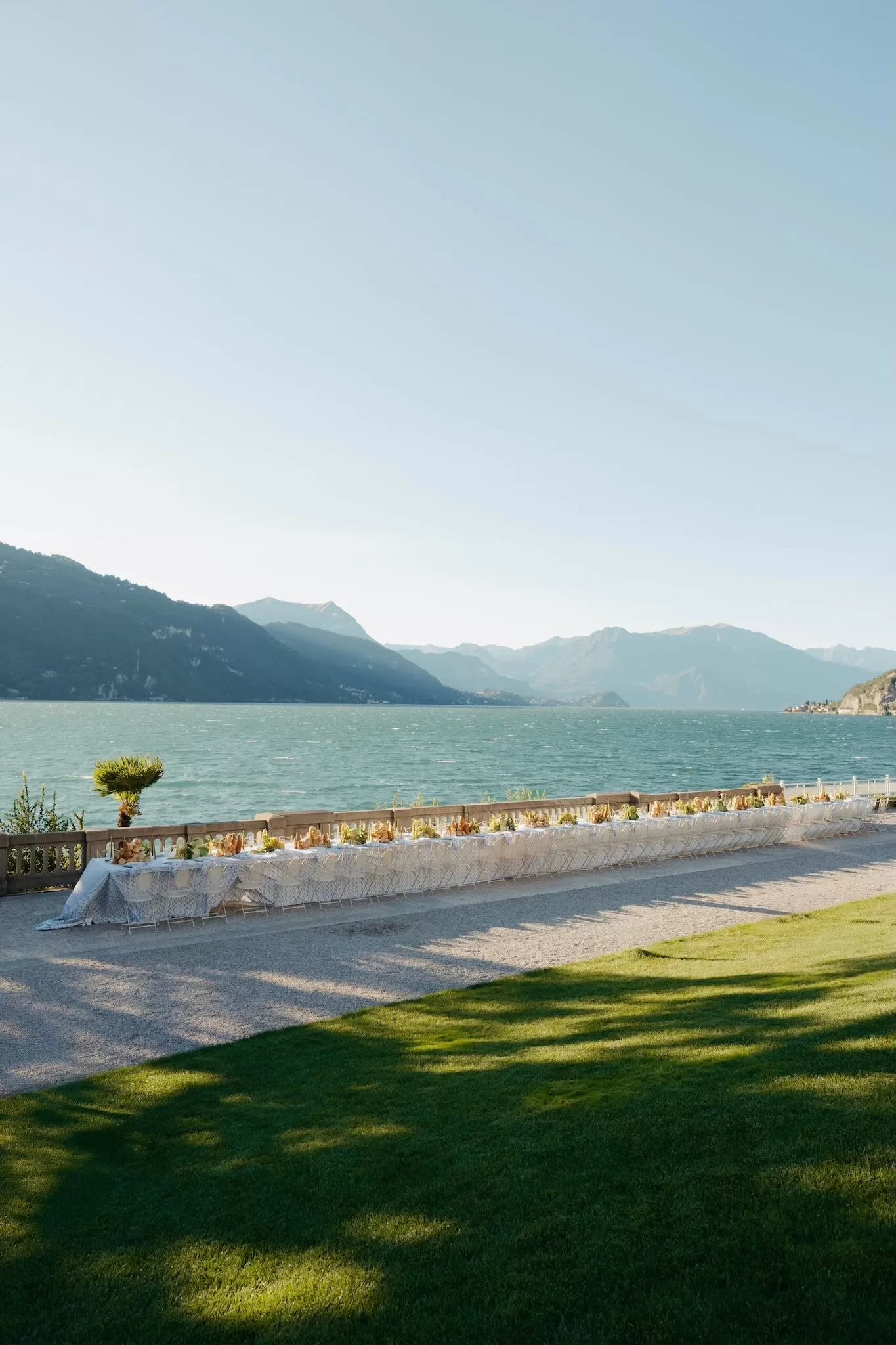 Wide view of an elegant lakeside banquet table set along the terrace at Villa Lario Resort
