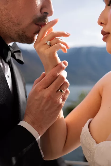 Intimate close-up of the couple’s hands and wedding rings in warm sunlight.