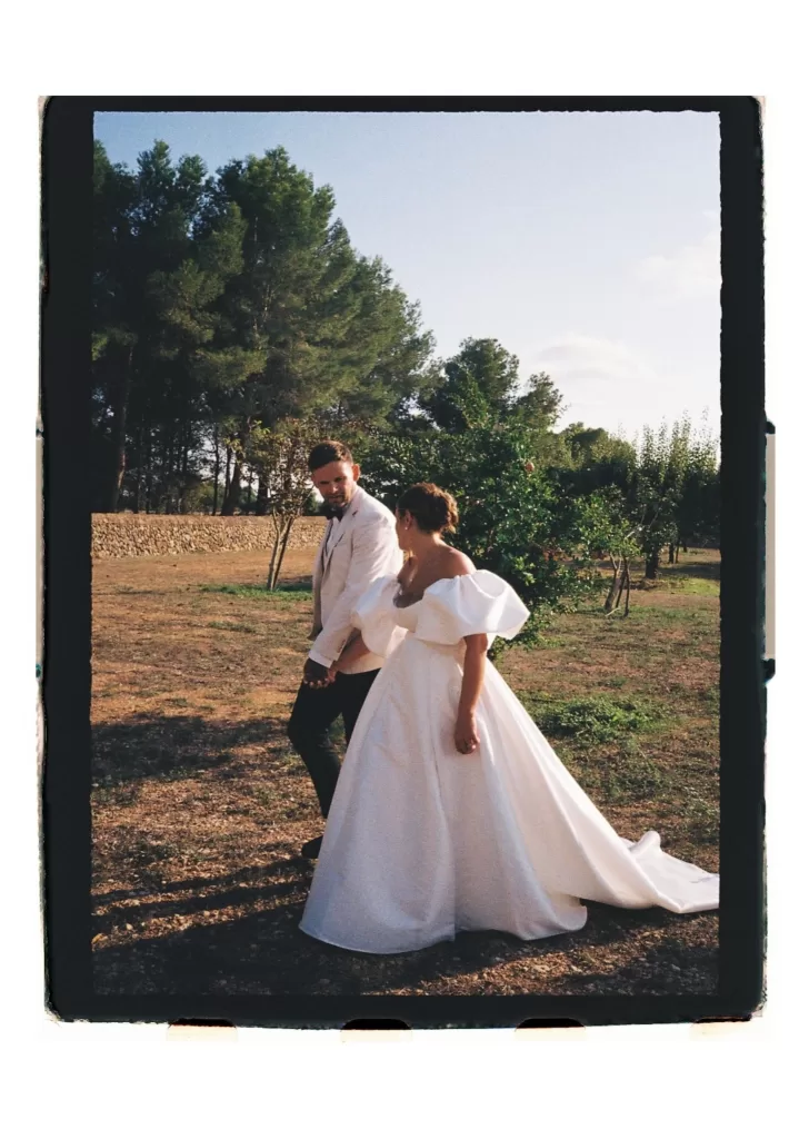 Bride and groom walking through countryside, soft light and natural surroundings