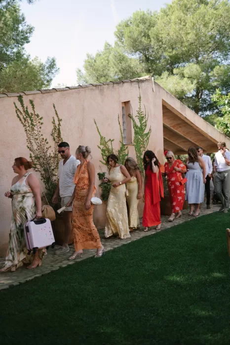 Guests walking along a garden path at a Mallorca finca in colorful summer wedding attire
