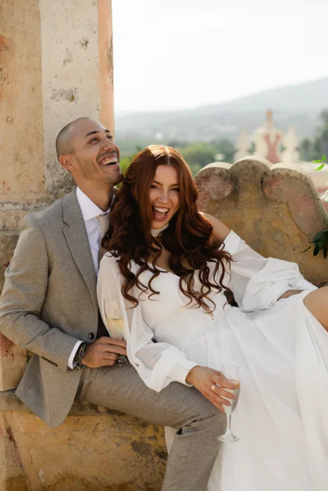 Bride and groom sharing champagne on a terrace at Pousada Palácio Estoi