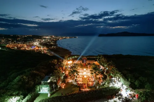 Sea View by En Kipo lit for an evening reception above the dark coastline.
