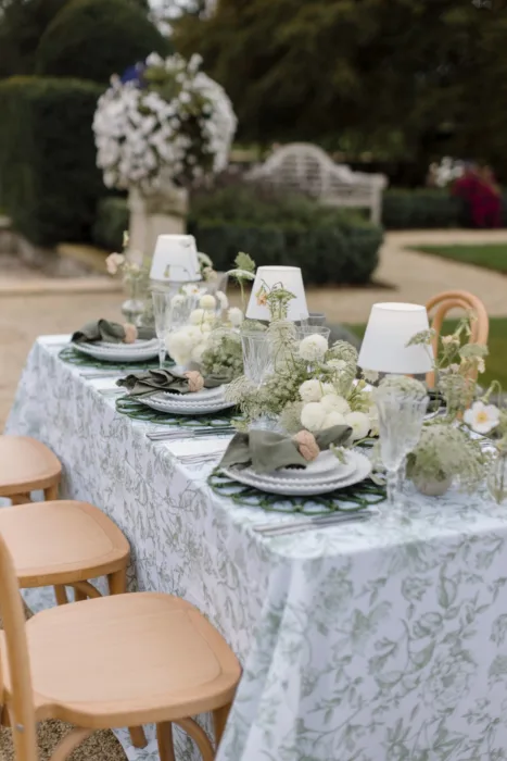 Outdoor reception table with white flowers, botanical table linen and garden-inspired styling