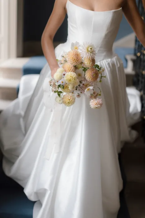Soft pastel bridal bouquet featuring dahlias and seasonal flowers.