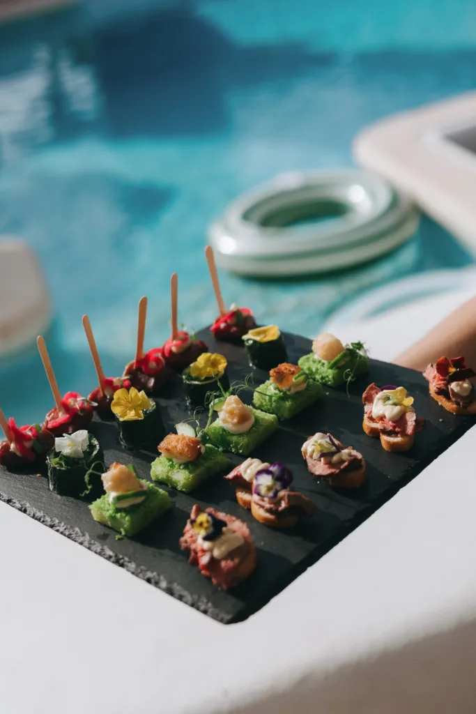 Colourful canapés are served beside the pool, with striped floats drifting in the background.