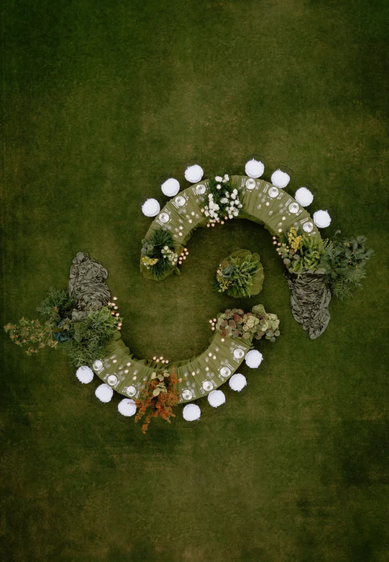 Drone view of the spiral dinner table, its curves softened by greenery and draped satin