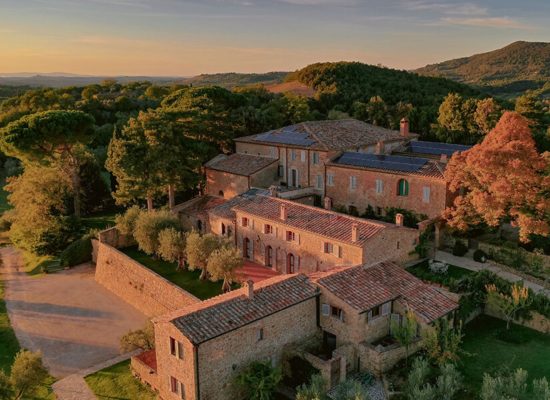 A panoramic view of Borgo Sant'Ambrogio, showcasing the historic stone buildings and lush gardens in the Tuscan countryside.