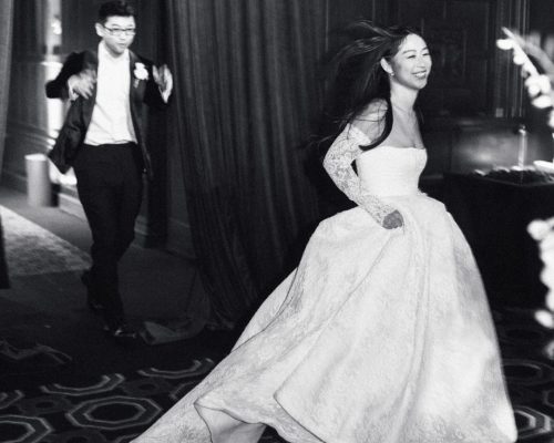 The bride lifts her wedding gown as she gracefully walks up the steps, captured by Studio Fotografico Bacci