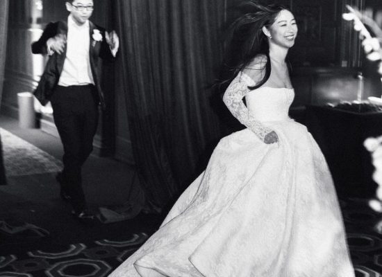 The bride lifts her wedding gown as she gracefully walks up the steps, captured by Studio Fotografico Bacci