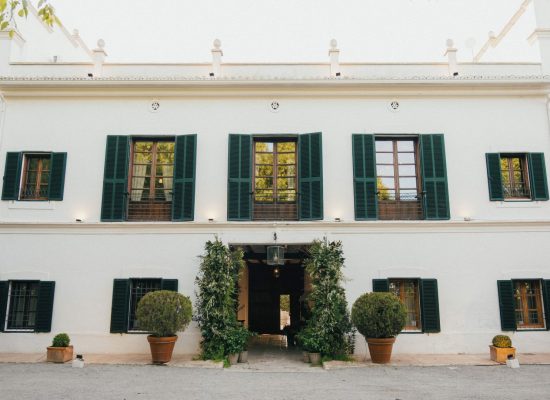 Stunning main exterior view of Masia Aldamar, a picturesque Spanish wedding venue surrounded by lush greenery.